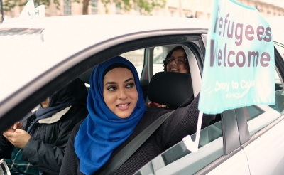 refugees-welcome-sign-held-by-woman-driving-car